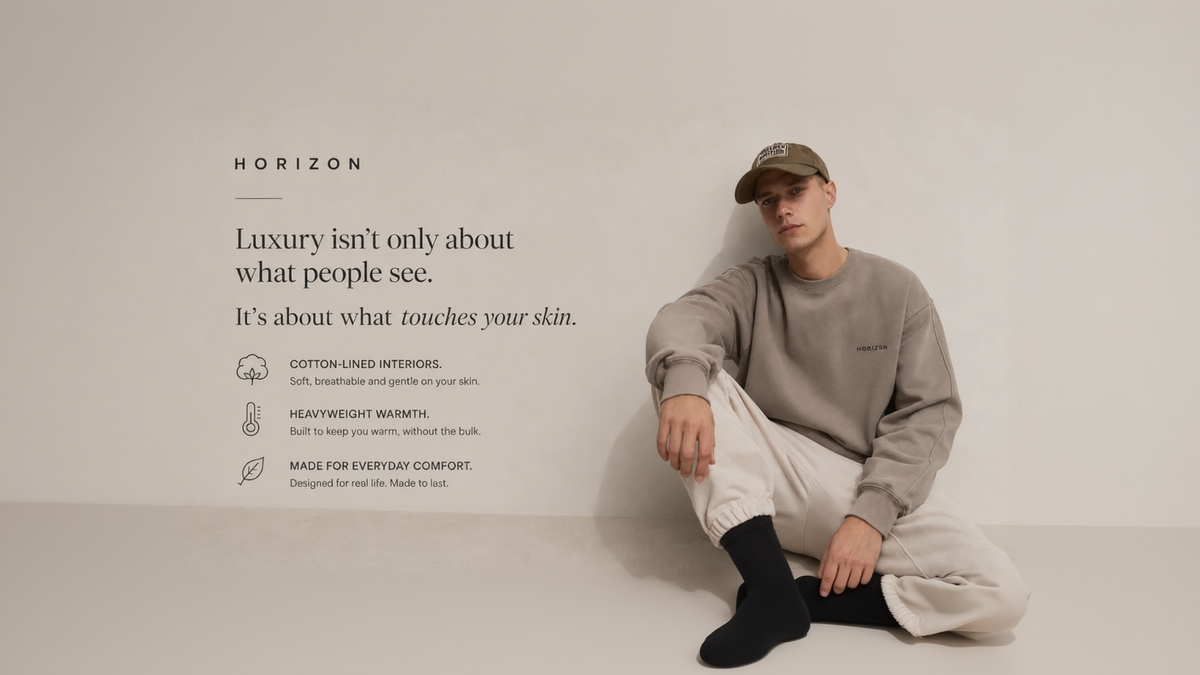 A man wearing a beige Horizon sweatshirt, beige joggers, and a brown baseball cap sits against a textured light beige wall, with product marketing text on the left.